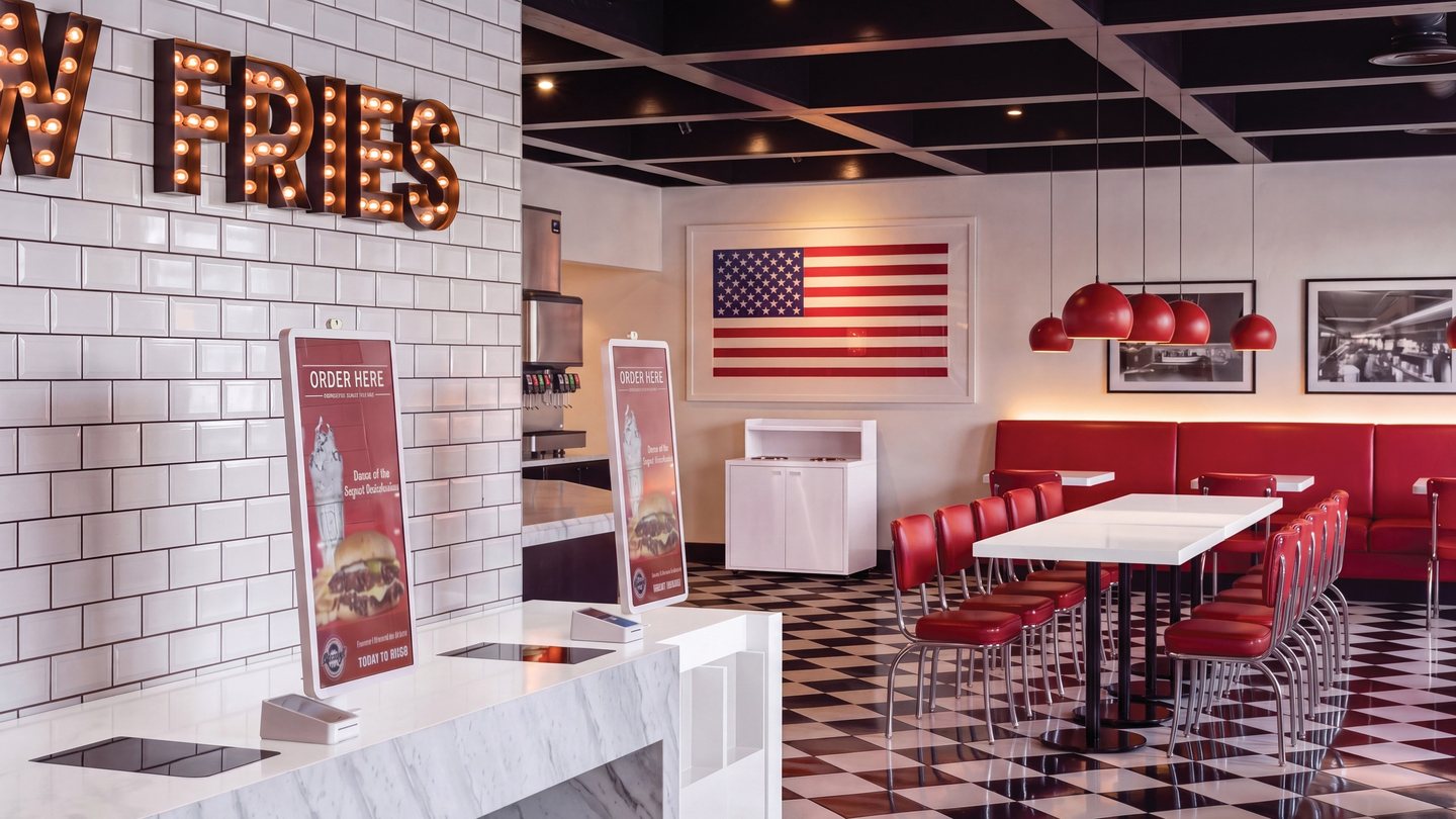 Steak ’n Shake restaurant interior with an order counter, fries sign, and red dining seats
